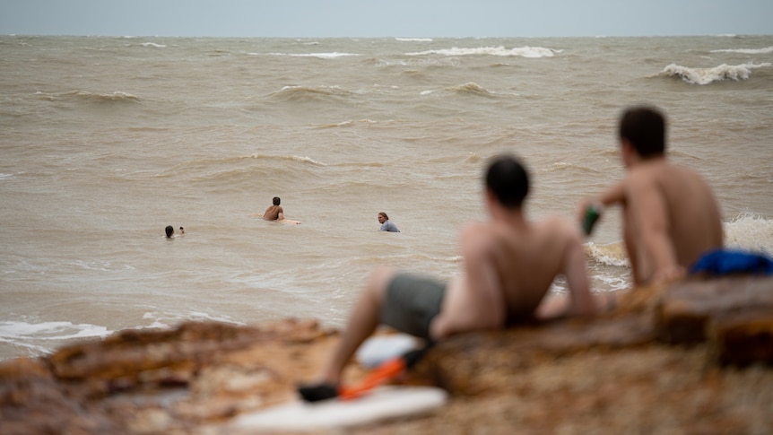 Onlookers watching heavy swell in the ocean at the Nightcliff foreshore. 