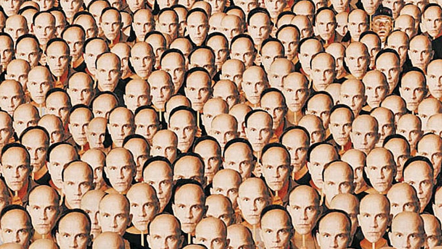 A crowd of people holding up John Malkovich masks to their faces