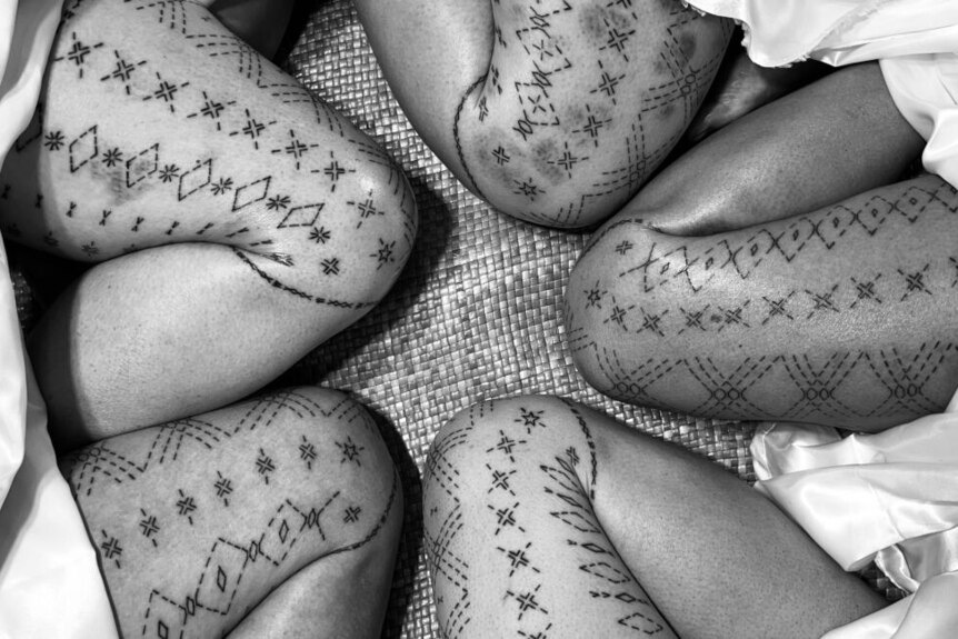 Black and white image of legs covered with Samoan tatau for women - the malu. 