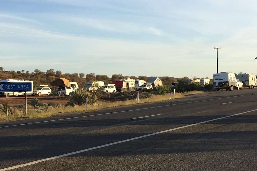 several cars and caravans camping out in a resting area in NSW hours before South Australia's tough COVID restrictions started.