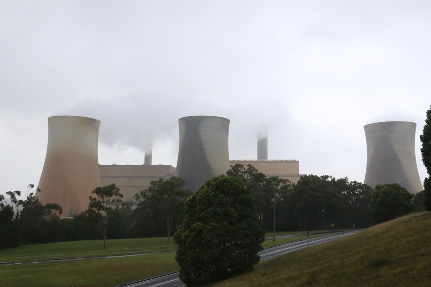 A power station with several chimneys releasing smoke