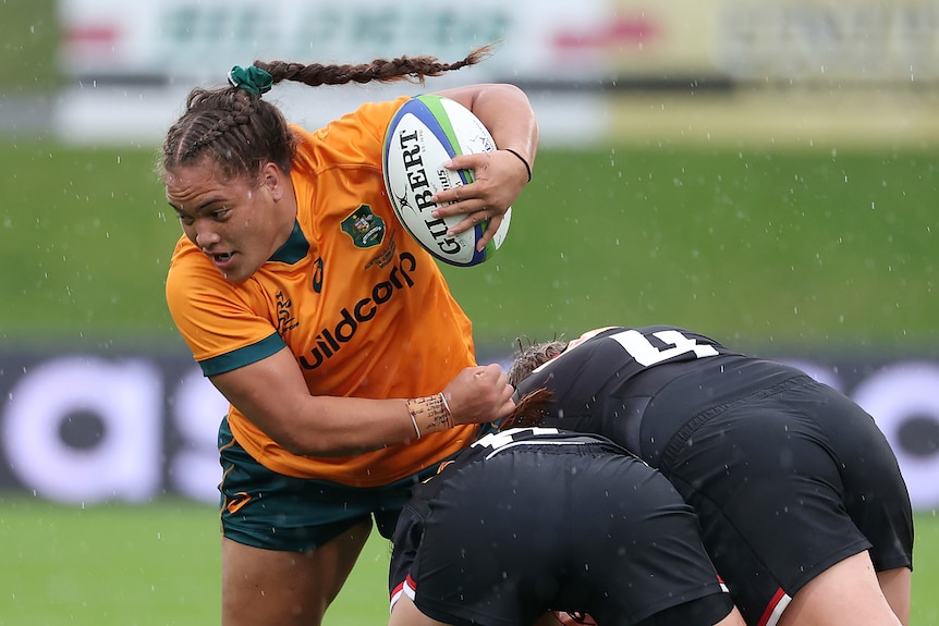 Ashley Marsters is tackled with the ball under one arm
