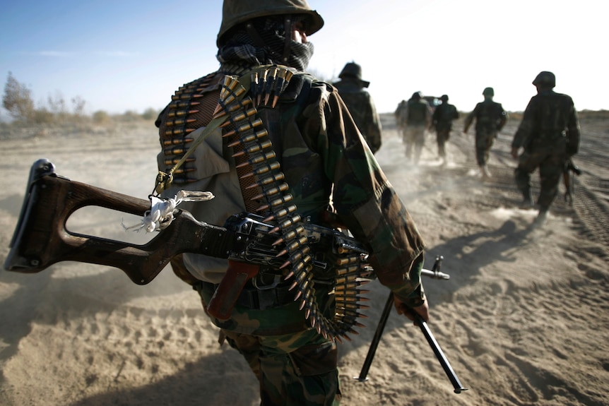 A soldier with bullet bandoliers strung across his chest 