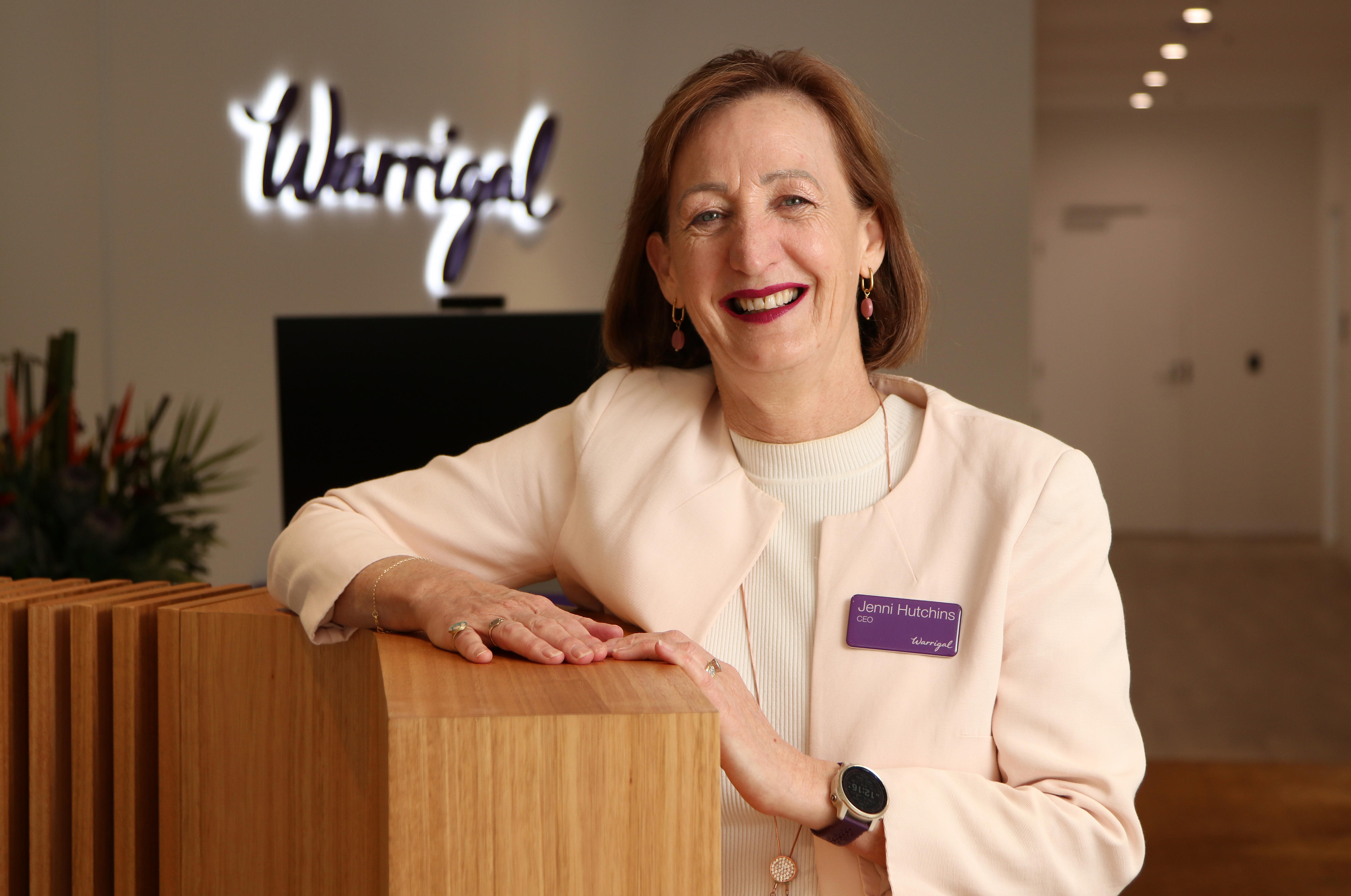 Woman leaning on a counter smiling