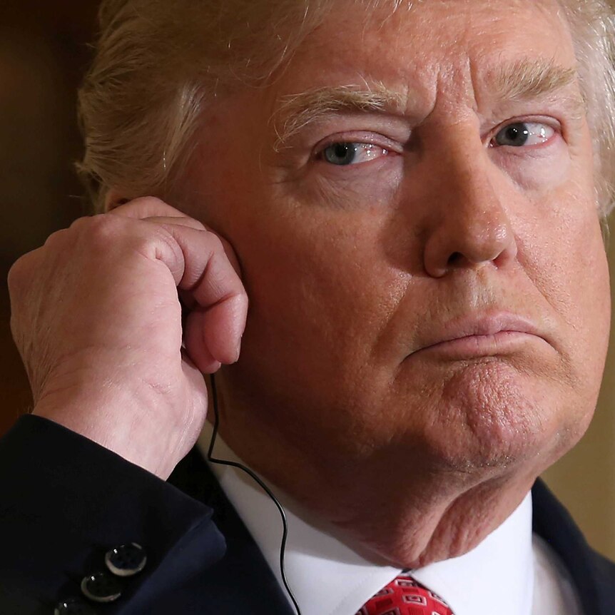 Donald Trump listens to a recording via an earpiece