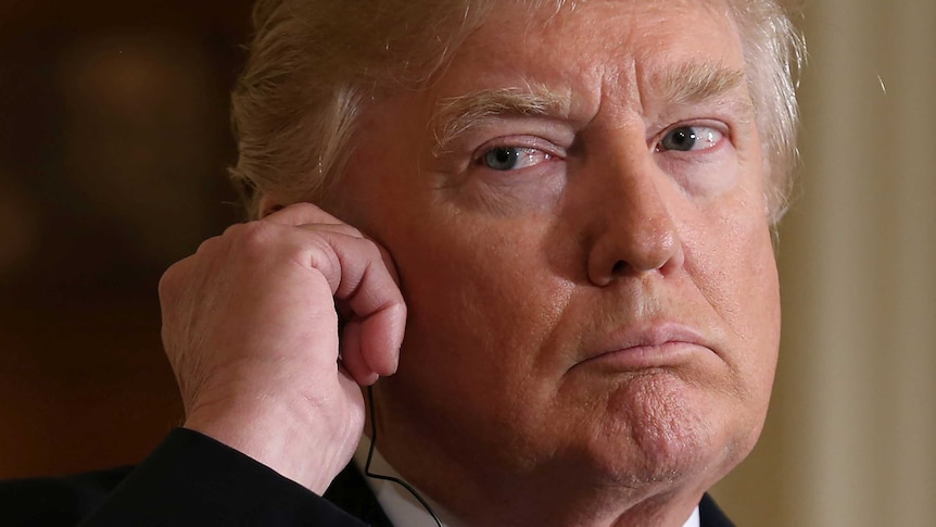 Donald Trump listens to a recording via an earpiece