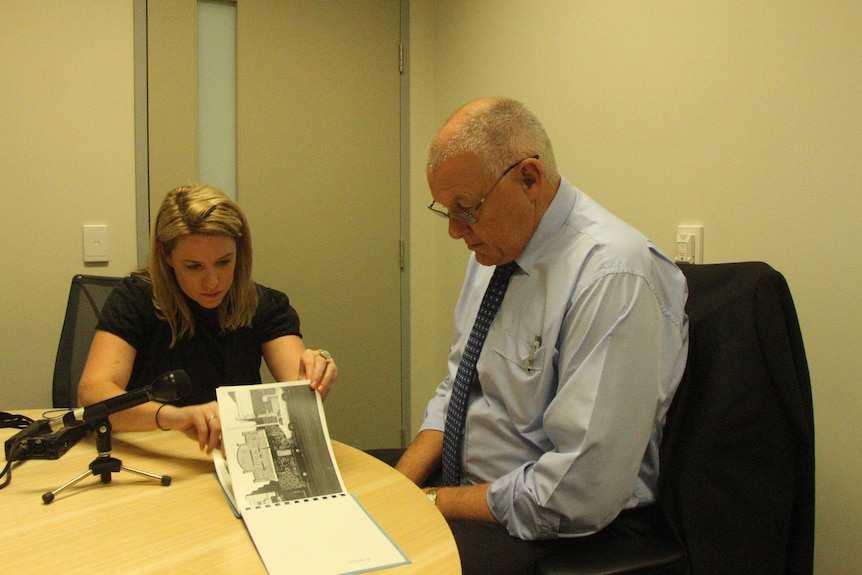 Rachael Brown and Ron Iddles looking at book of photographs.