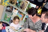 Tony Abbott, right, with his wife Margaret, read to some young children