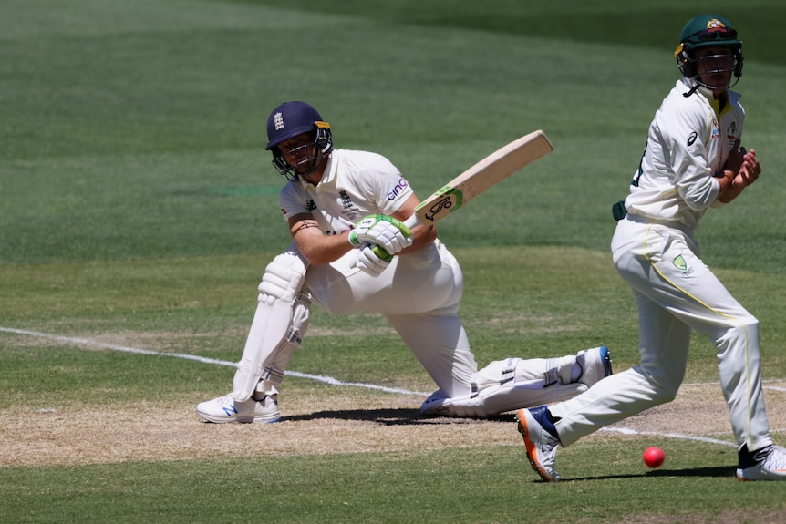 Jos Buttler plays a sweep shot as Marnus Labuschagne leaps out of the way