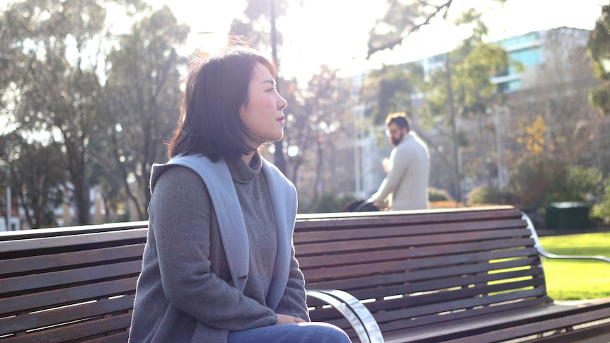 A Chinese woman sitting in a park