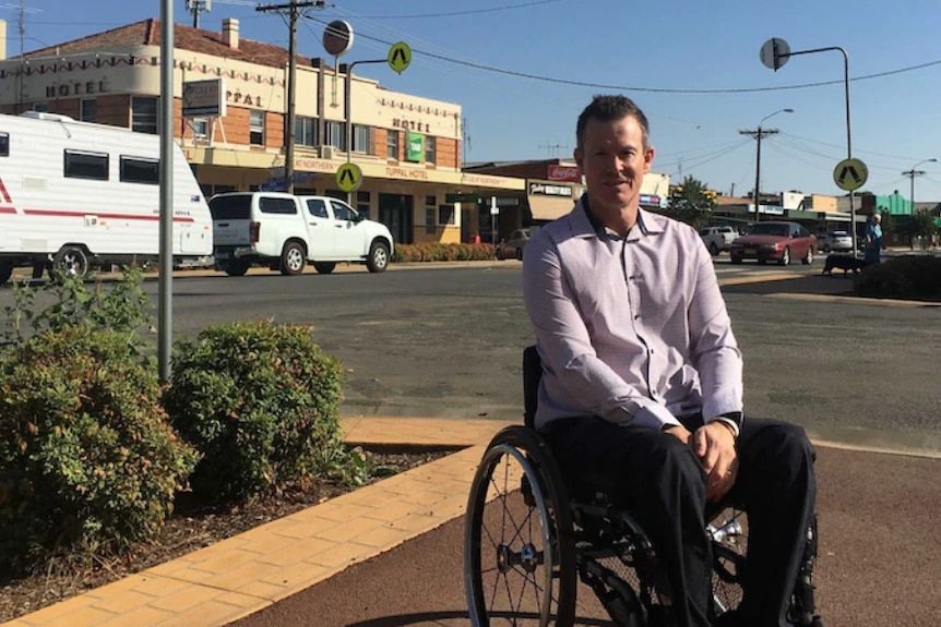 man in wheel chair on a footpath