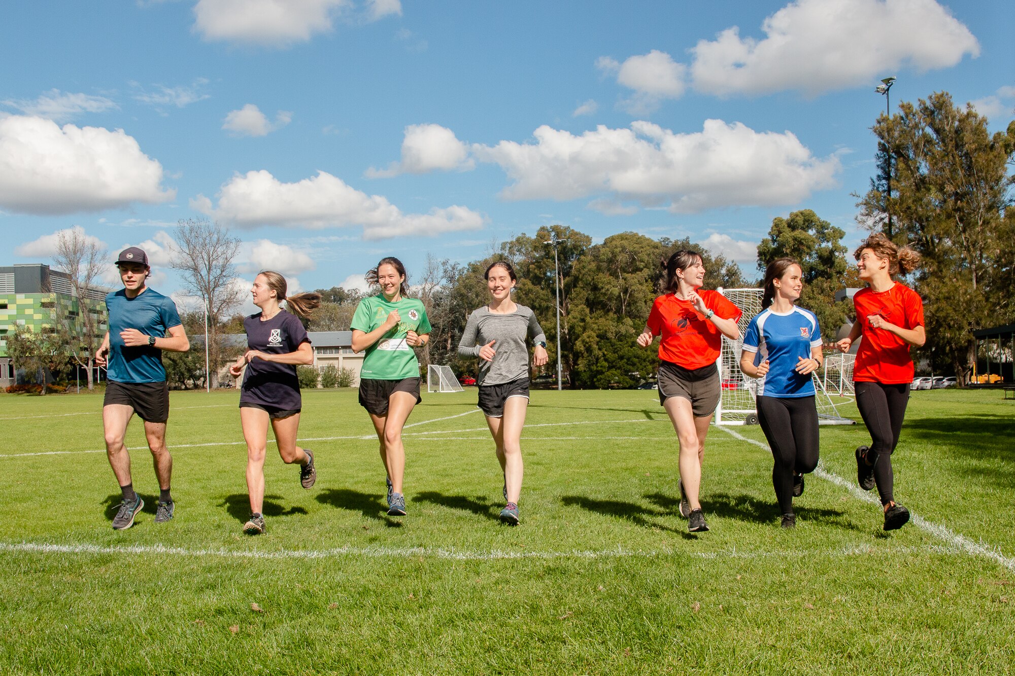 7 young adults run towards the camera