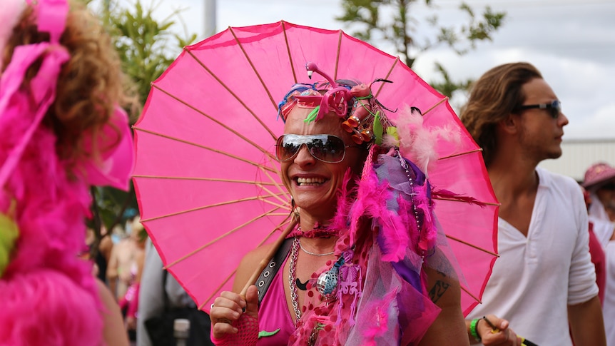 Parade entrant holding pink umbrella
