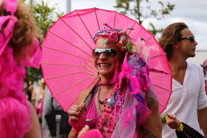 Parade entrant holding pink umbrella