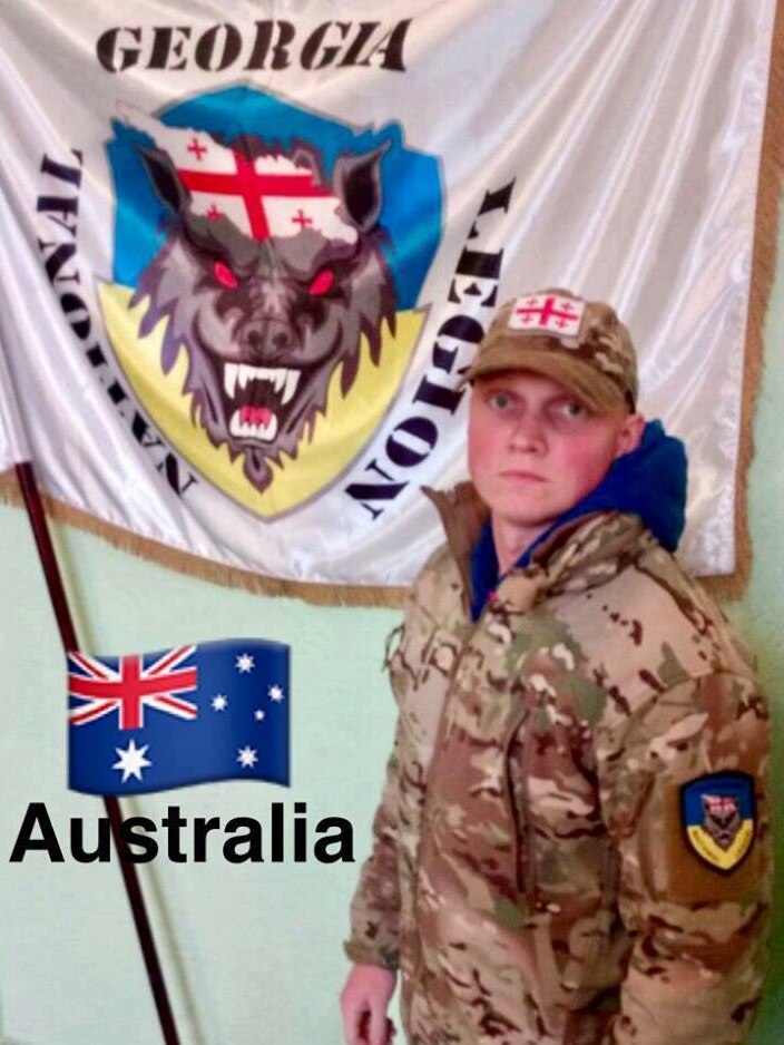 Ethan in uniform in front of a legion flag.
