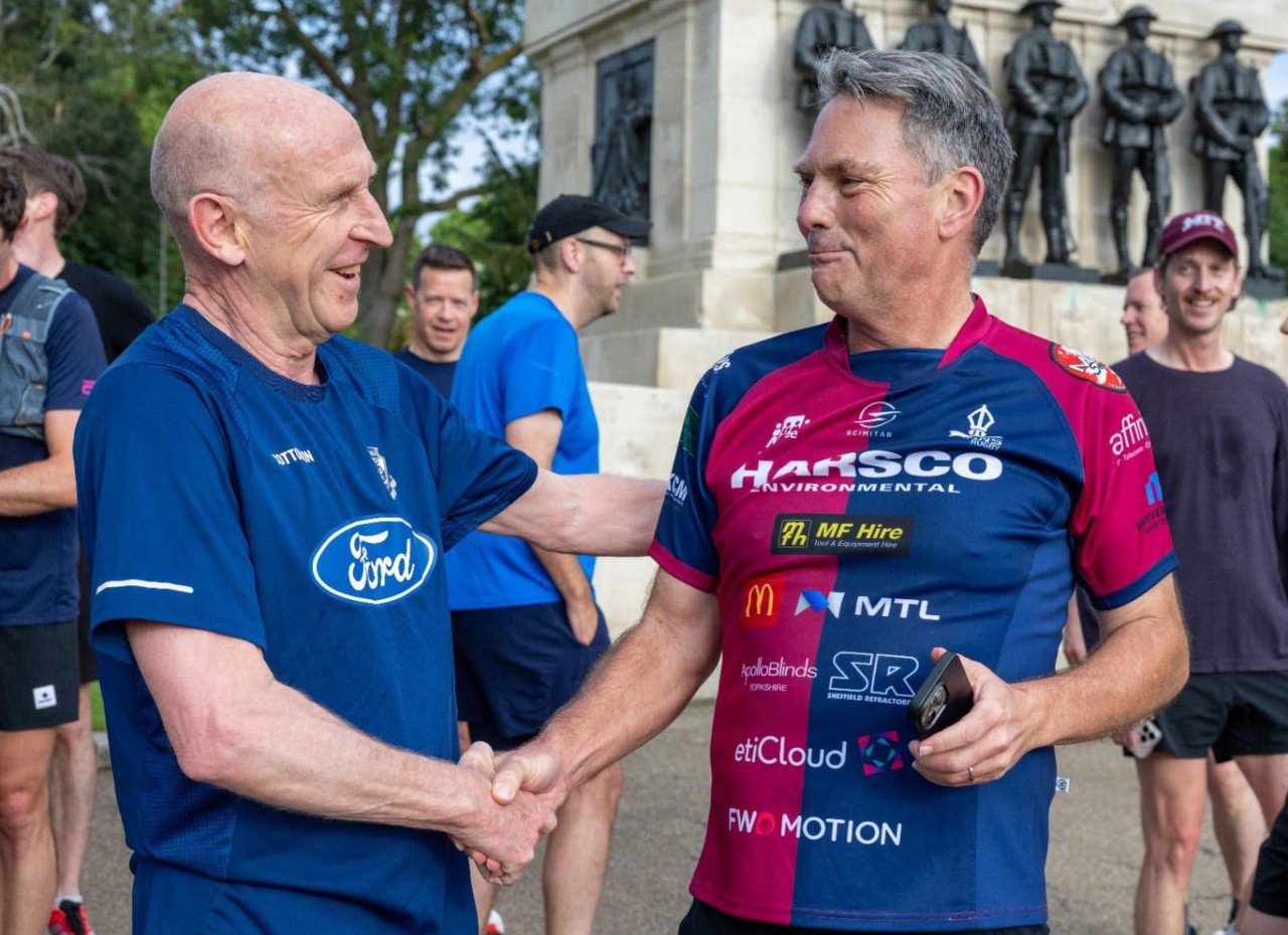 Two men shaking hands and smiling 