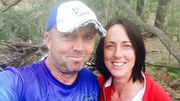 A middle aged couple take a selfie in bushland.