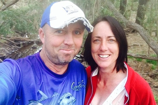 A middle aged couple take a selfie in bushland.