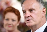 Mark Latham speaks with Pauline Hanson in the background.