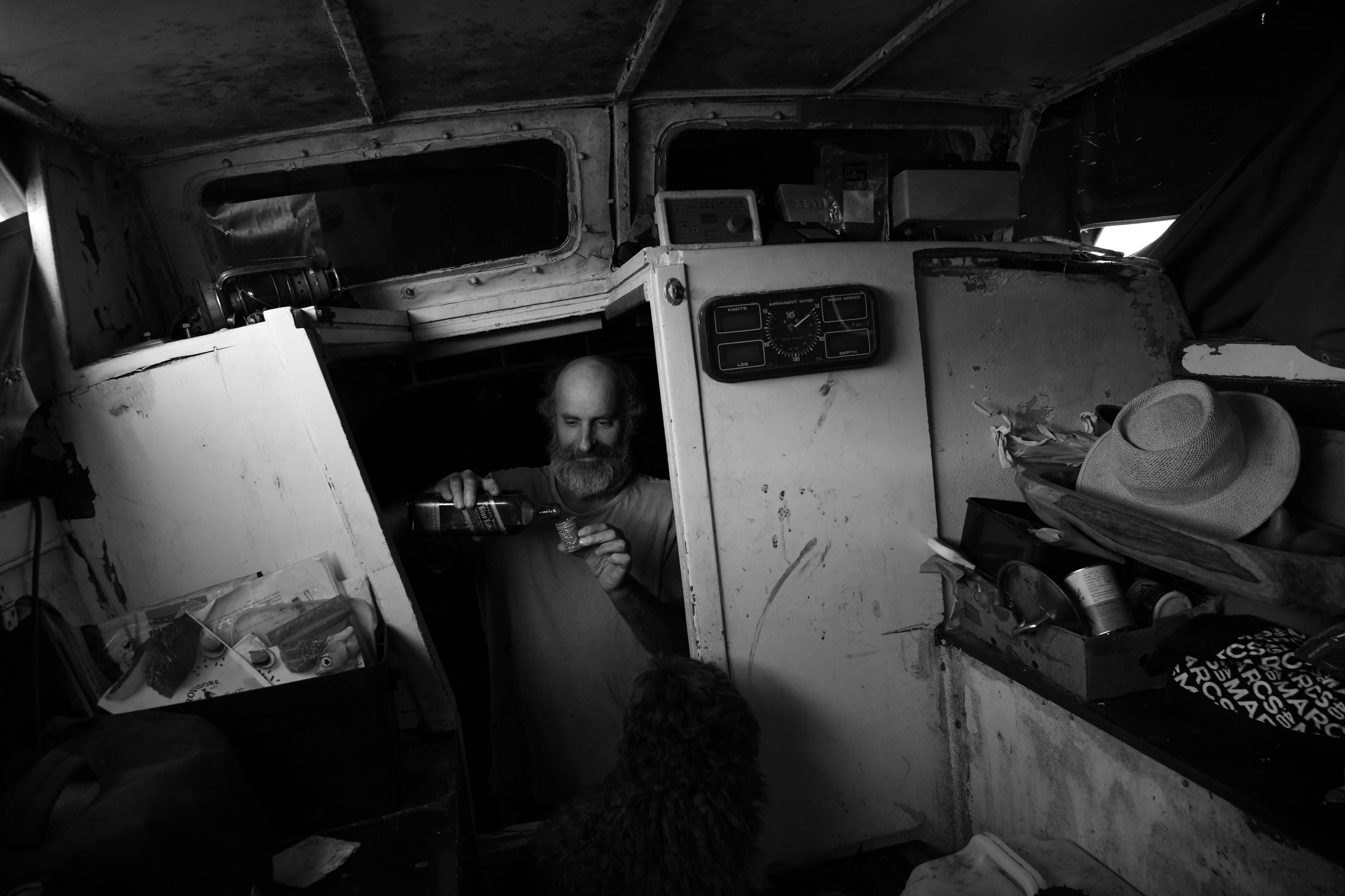 A man pours out alcohol into a shot glass