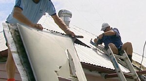 Builders help to repair windows damaged in the storm.
