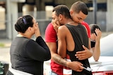 Friends and family members embrace outside the Orlando Police Headquarters