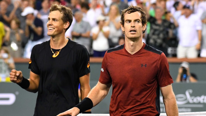 Andy Murray (R) leaves the court after losing to Vasek Pospisil in straight sets.