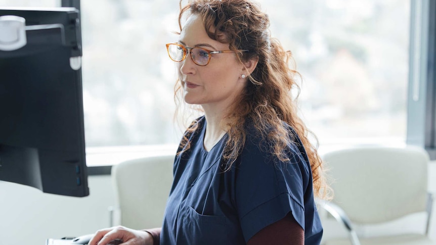 nurse looking at a computer screen