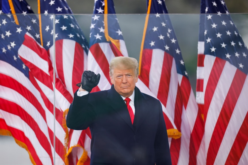 US President Donald Trump raises his fist while speaking at a January 6, 2021 meeting.