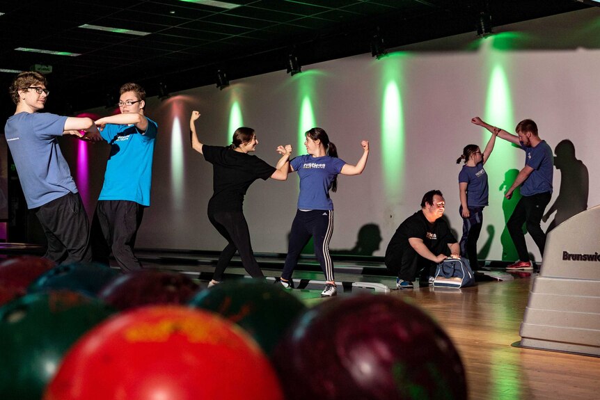 A dance troupe performing in a bowling alley.