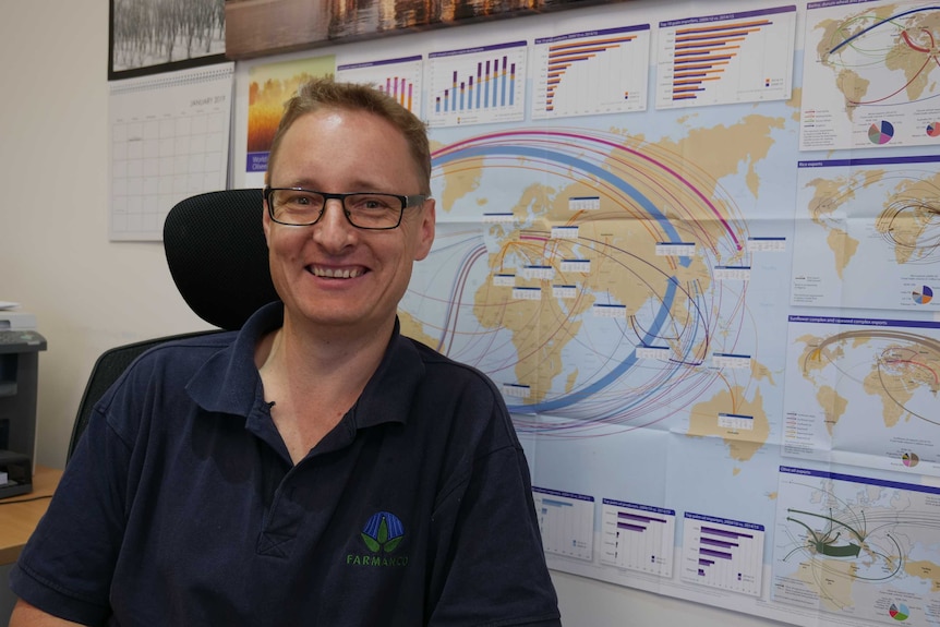 Grain marketer Don McTaggart sits in his office in front of a map.