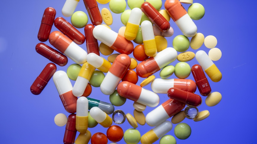 A pile of capsules and tablets of different sizes, shapes and colors.