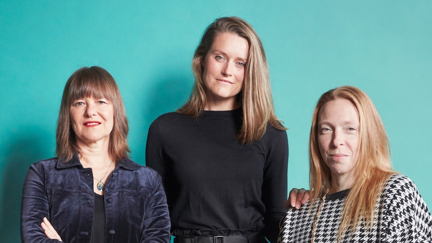 Portrait of choreographers Lucy Guerin, Stephanie Lake and Jo Lloyd with a turquoise backdrop