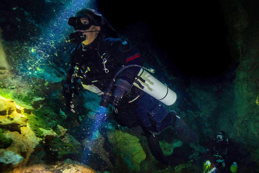 A diver under water in the dark