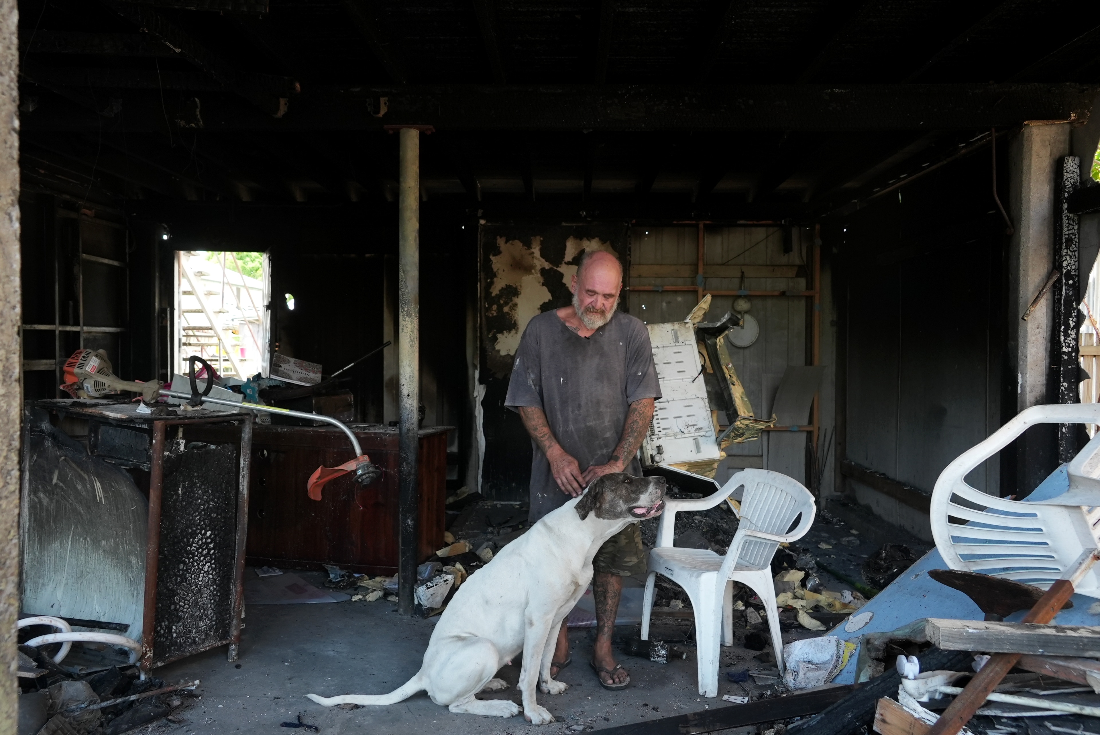 A man and his dog in the burnt remains of a home