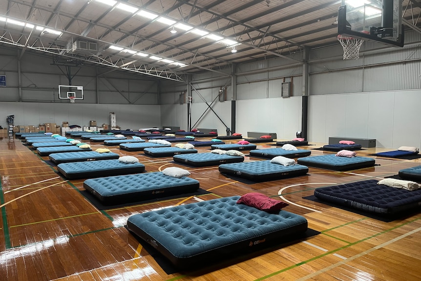 Air mattresses set up on the courts of a basketball stadium