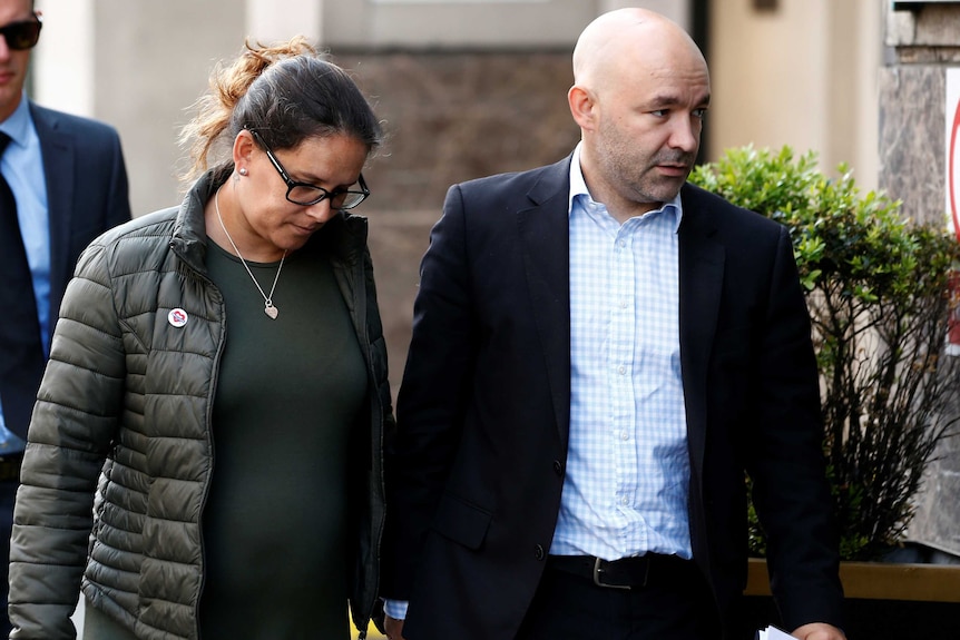 Marcio and Andreia Gomes, parents of Logan Gomes, walk hand in hand.