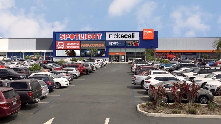 A carpark in front of a shopping centre with signs for Spotlight, Fantastic Furniture, Anaconda and Pet Stock