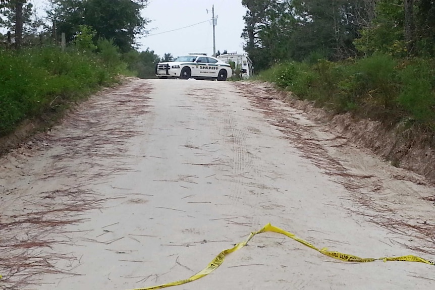 A Sheriff's patrol vehicle blocks access to the scene of a murder-suicide in Bell, Florida