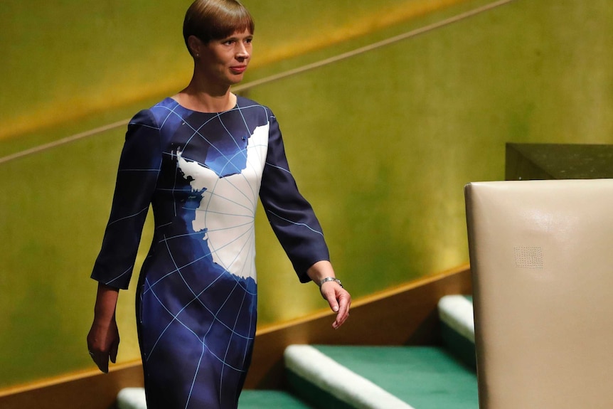 Estonian President Kersti Kaljulaid walks into a room with a big chair.