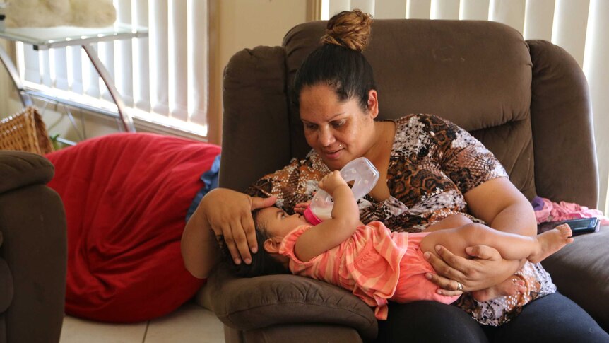 Megan Naden holds one of her twin girls at the Gomeroi gaaynggal centre in Tamworth.