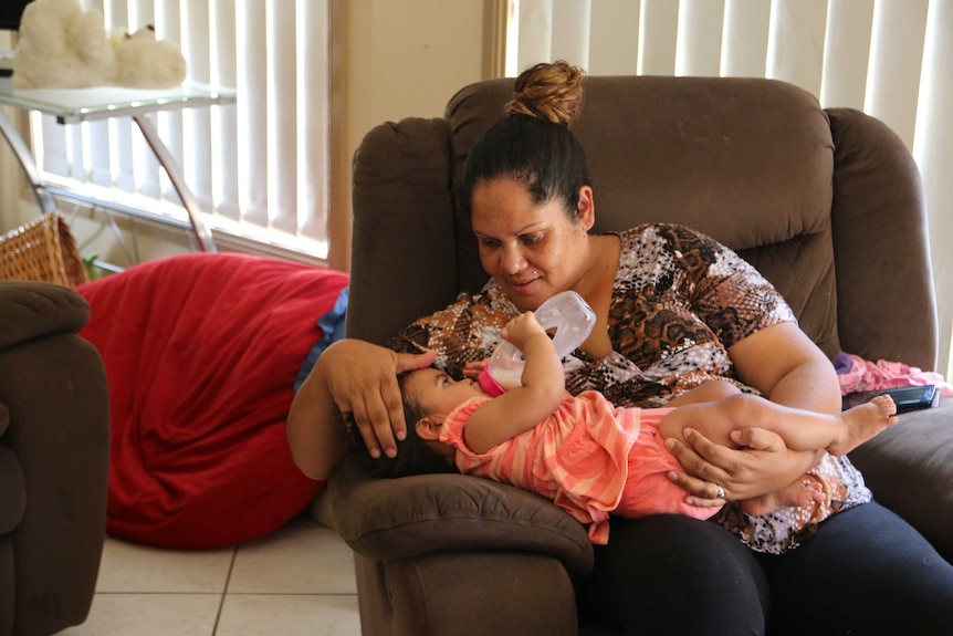 Megan Naden holds one of her twin girls at the Gomeroi gaaynggal centre in Tamworth.