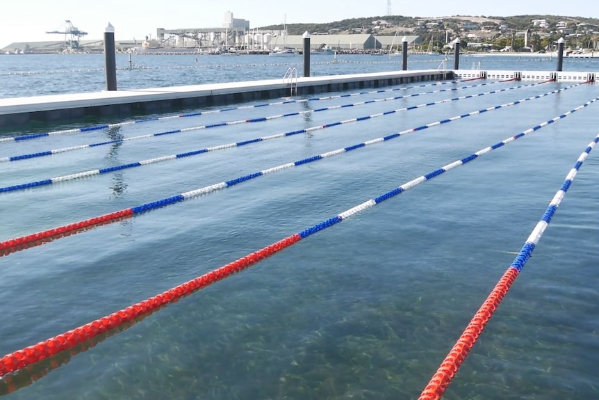 A picture of the pool from standing above it, the port is in the background, the water is fairly clear