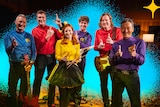 Photo of six Wiggles (including Emma as yellow wiggle) in skivvies at the triple j studio doing finger guns