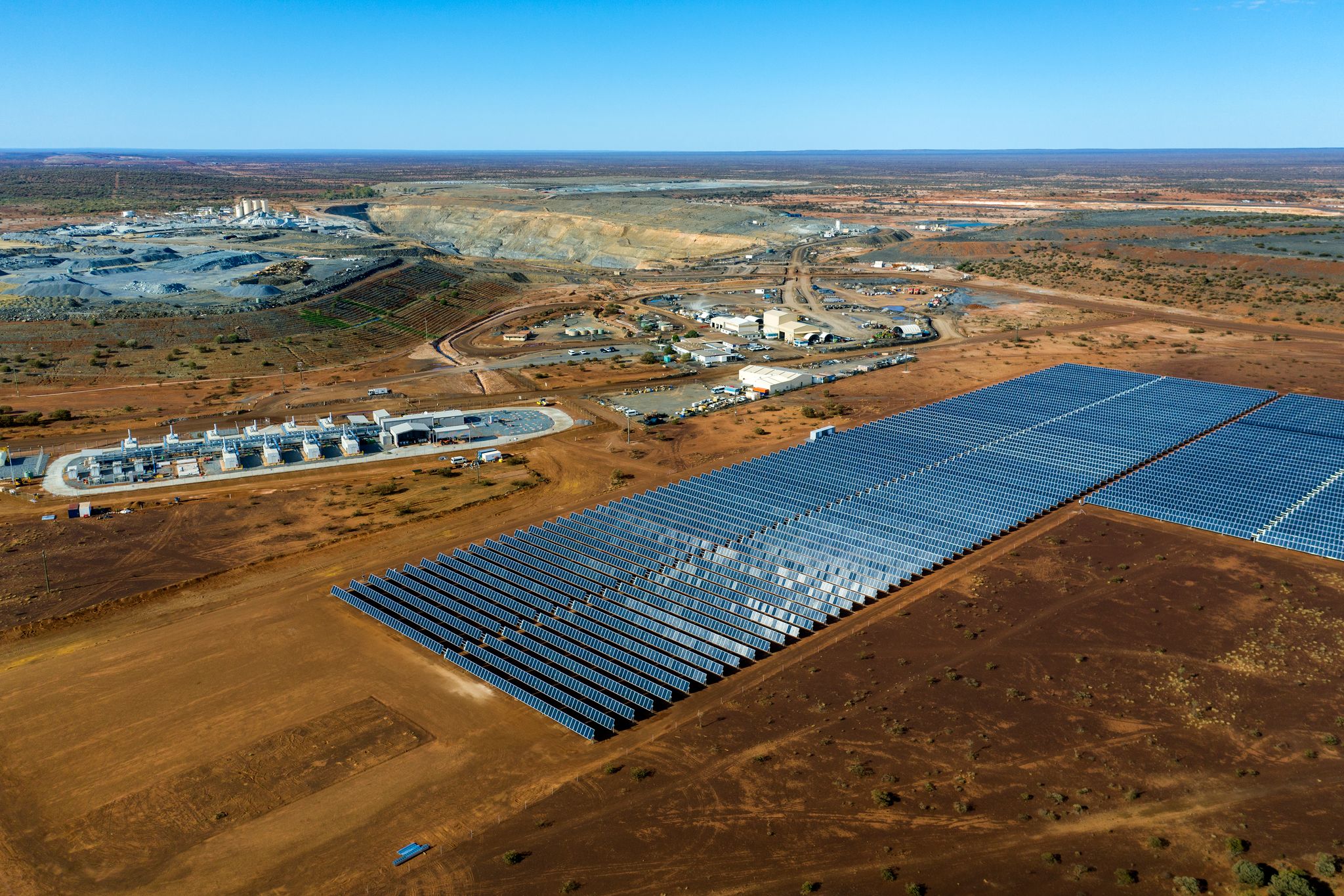 Aerial shot looking down at mine with solar farm and gas-fired generator and battery in foreground