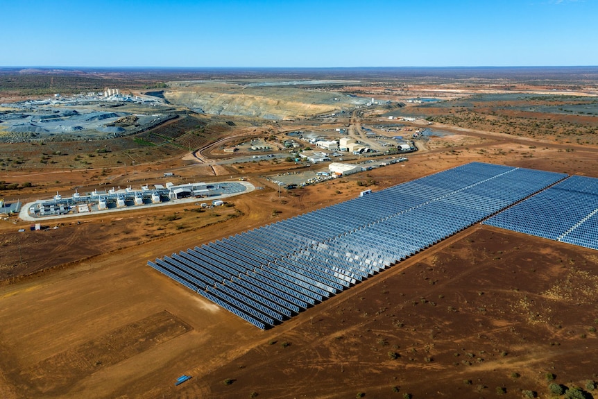 Aerial shot looking down at mine with solar farm and gas-fired generator and battery in foreground