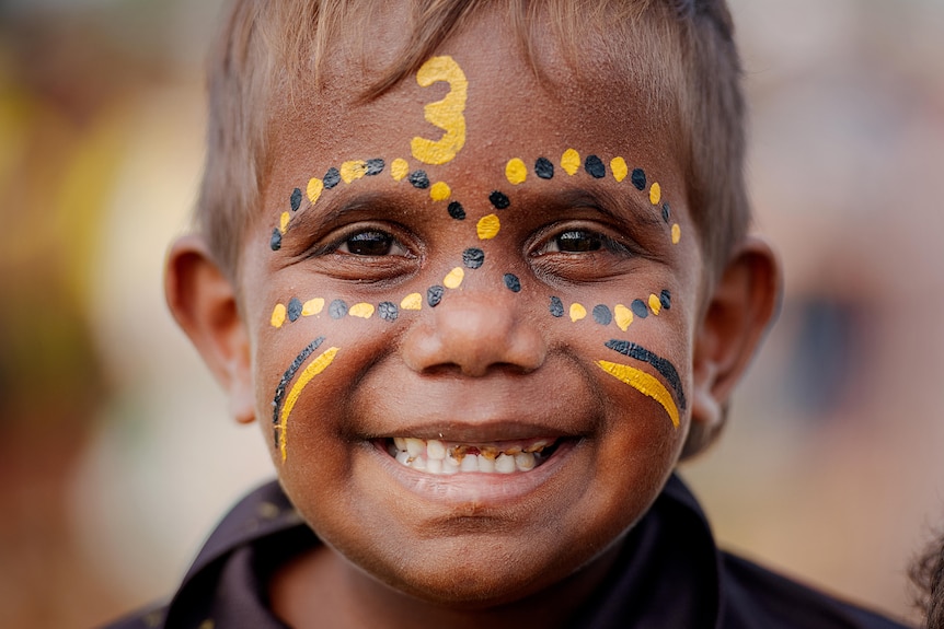 a young boy wearing face paint smiles