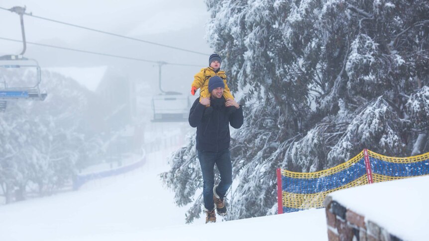 A child getting a piggyback gazes in wonder at a snowy landscape.