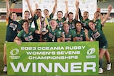 The Australian women's rugby sevens team celebrates with the Oceania Rugby Sevens championship trophy
