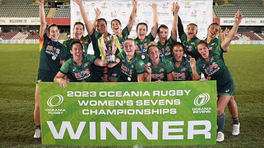 The Australian women's rugby sevens team celebrates with the Oceania Rugby Sevens championship trophy